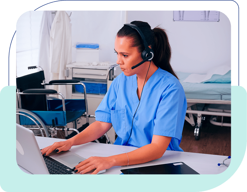 Nurse using laptop with headset in hospital.