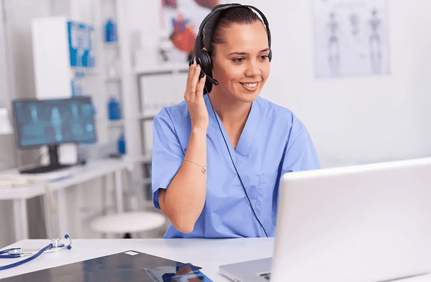 Smiling nurse on video call in office.